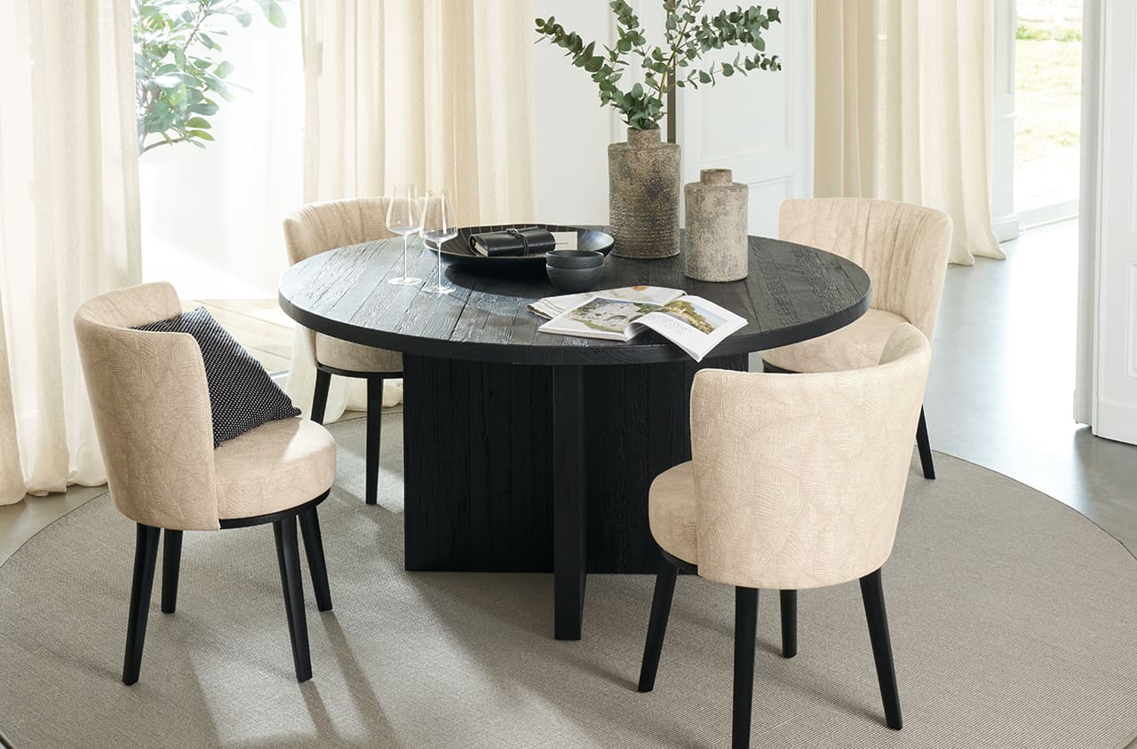 Moderne Esszimmerstühle in Beige mit Polsterung und dunklem Holzgestell an einem runden Esstisch.